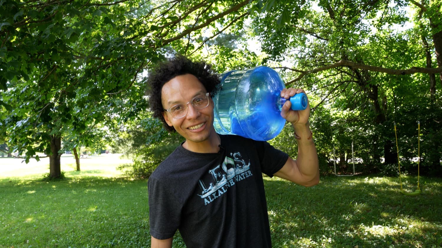 Leo carrying a 5-gallon jug of alkaline water